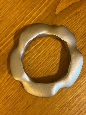 Silver tone wooden bangle that is wavy in shape 7 3/4 “